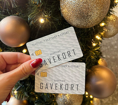 Billede af gavekort der bliver vist frem foran juletræ